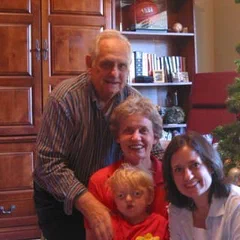 A family of four by a Christmas tree