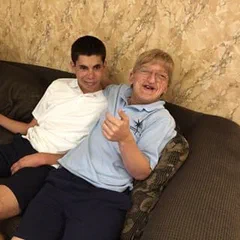 Alex and a friend on a couch, one laughing