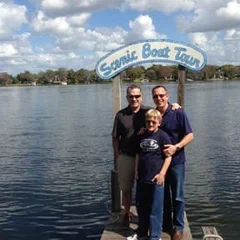 Alex and family on a dock with a lake behind them