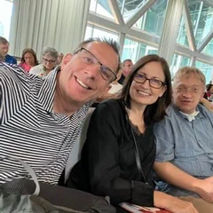 Four people smiling together in a bright room
