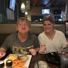Alex and a family member sharing a meal at a restaurant