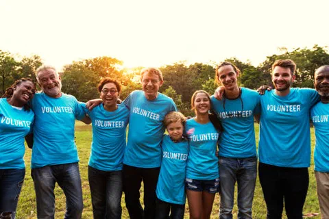 A group of volunteers in matching blue shirts standing together outdoors